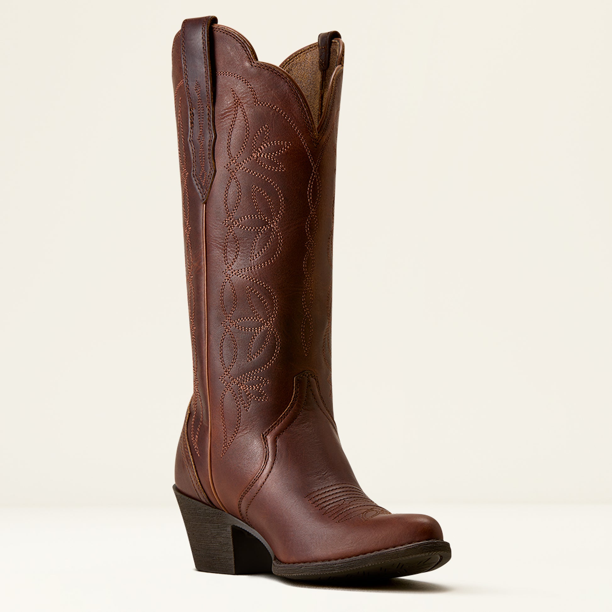 A single brown leather cowboy boot with decorative stitching, a low block heel, and a square toe, photographed against a clean off-white background.