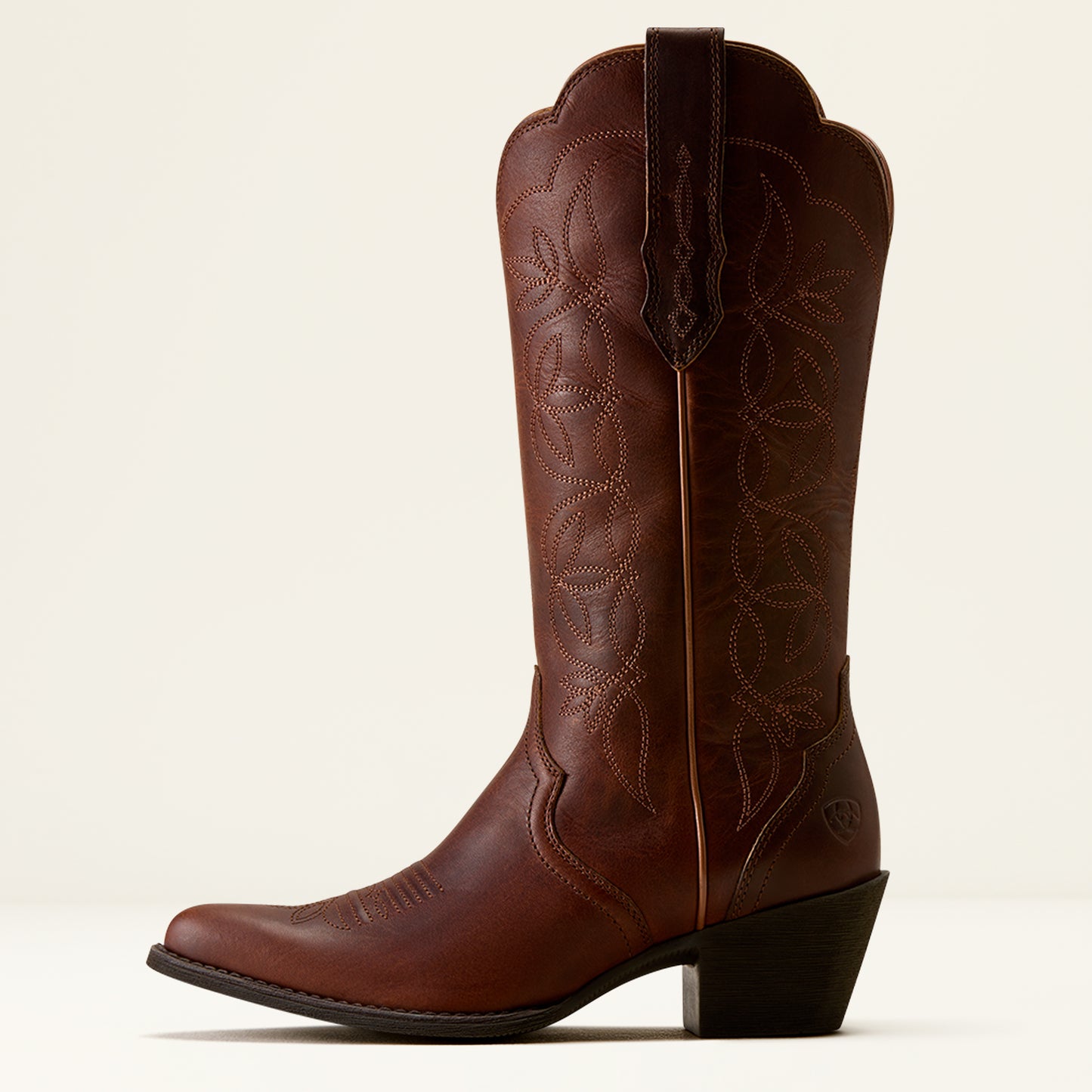 Brown cowboy boot with intricate design on a white background