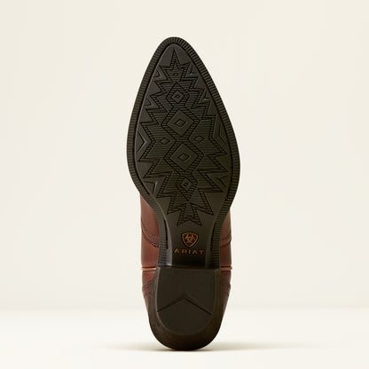 A close-up studio shot of the outsole of a brown leather cowboy boot, showing a black treaded pattern and the Ariat logo near the heel, on a light beige background.