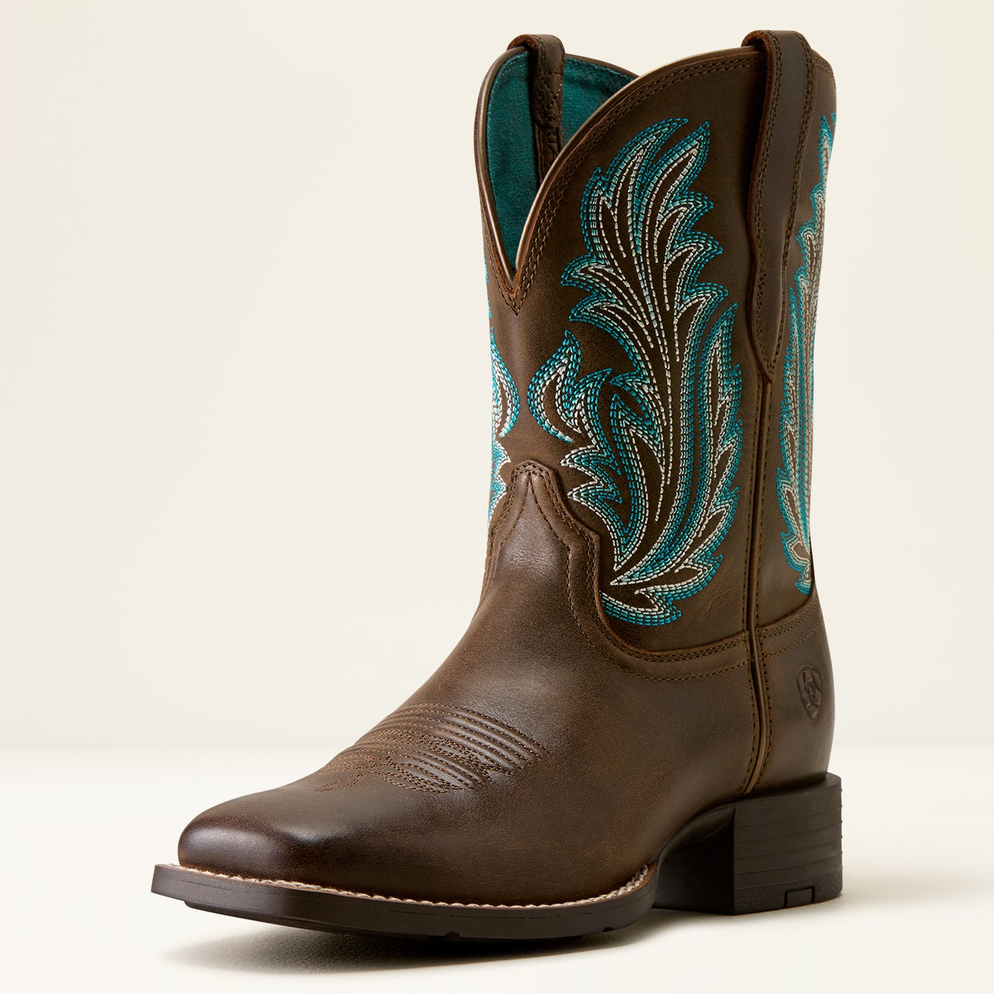 Brown cowboy boot with turquoise embroidery on a white background