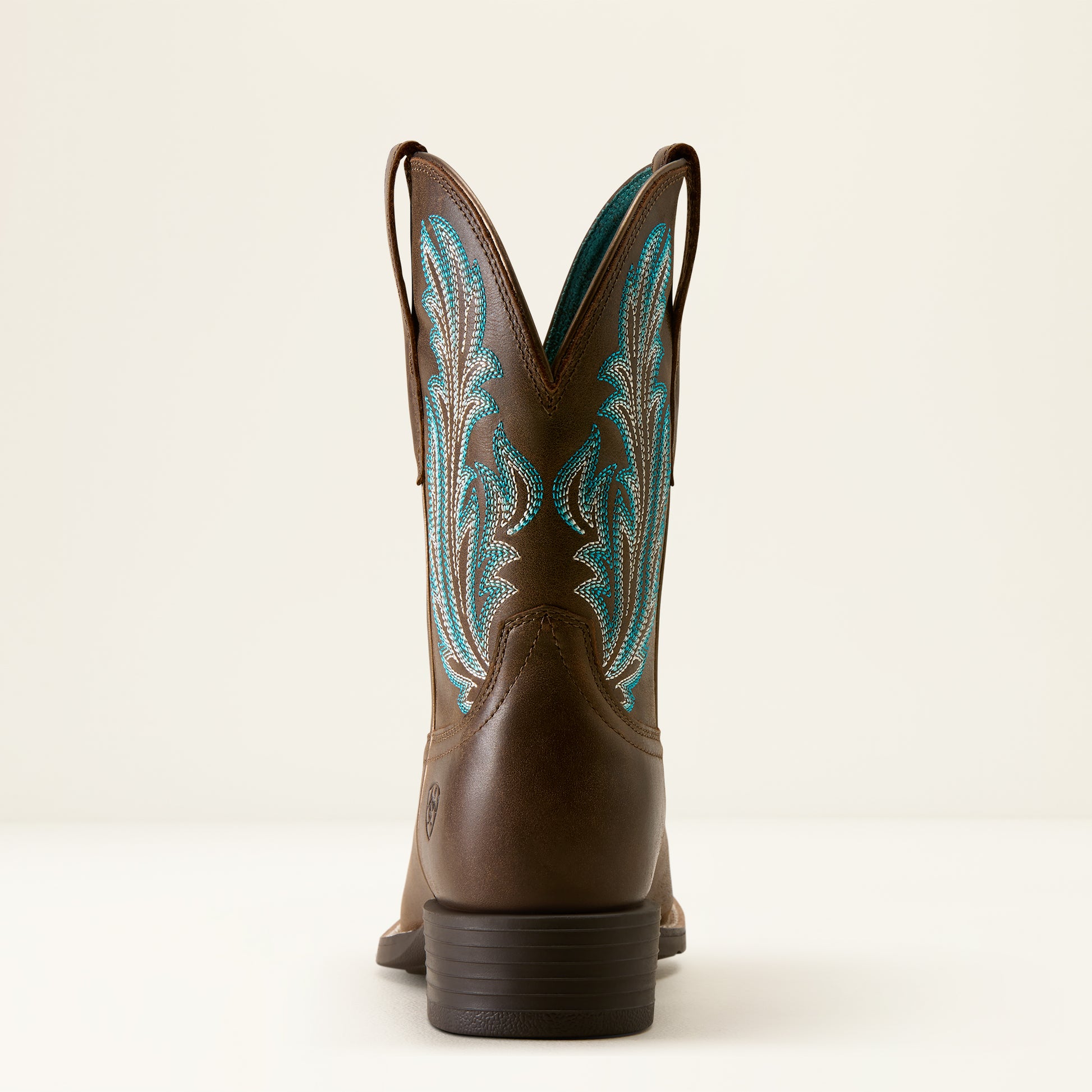 the back of a brown cowboy boot with turquoise stitching