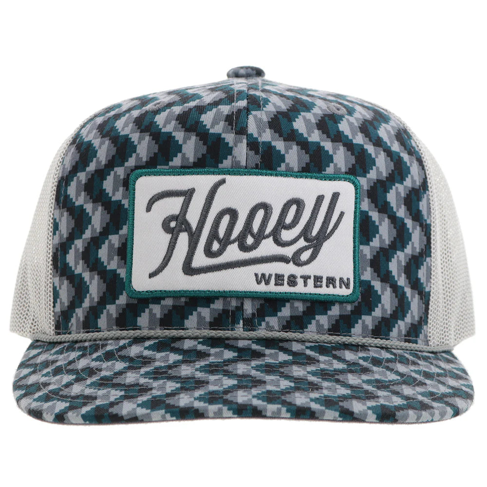 a chevron printed teal and grey trucker cap with a patch that says 'hooey western' on a white background