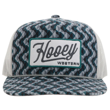 a chevron printed teal and grey trucker cap with a patch that says 'hooey western' on a white background