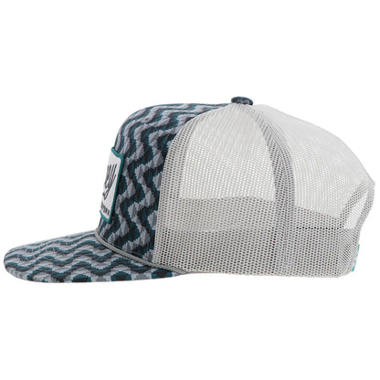a chevron printed teal and grey trucker cap with a patch that says 'hooey western' on a white background