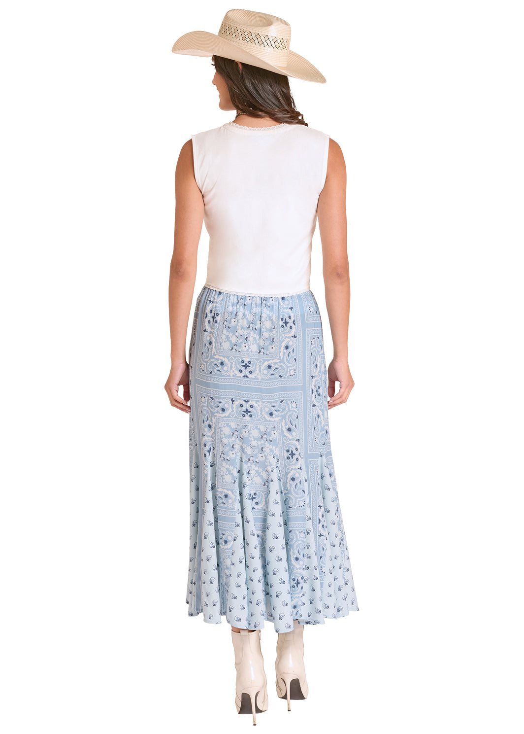 Woman wearing a white sleeveless top and light blue Panhandle Slim floral skirt with a beige hat on a white background