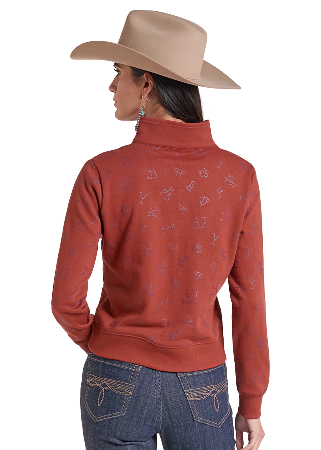 Woman wearing a pullover sweater by Panhandle Slim in rose color with blue jeans and a tan cowboy hat on a white background