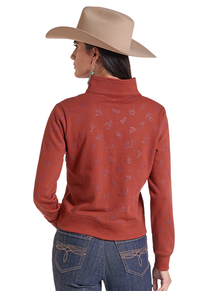 Woman wearing a pullover sweater by Panhandle Slim in rose color with blue jeans and a tan cowboy hat on a white background