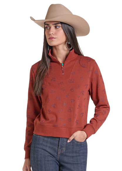 Woman wearing a pullover sweater by Panhandle Slim in rose color with blue jeans and a tan cowboy hat on a white background