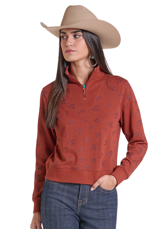 Woman wearing a pullover sweater by Panhandle Slim in rose color with blue jeans and a tan cowboy hat on a white background