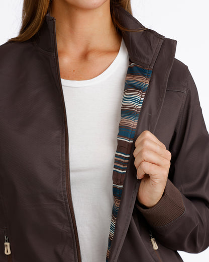 Woman wearing a brown Cinch jacket and a white t shirt on a white background