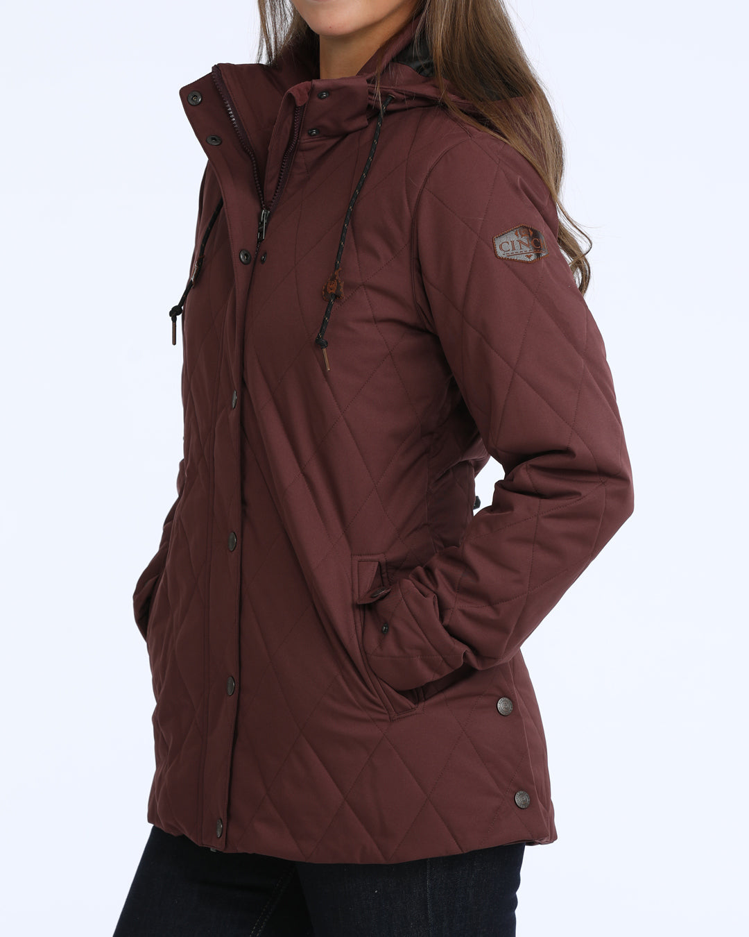 woman wearing a purple Cinch jacket and dark blue jeans on a grey background