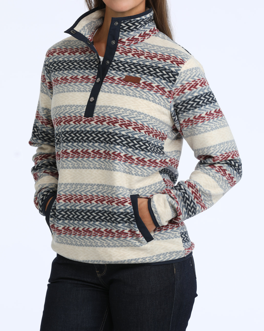 woman wearing a multi colored fleece Cinch sweater and blue jeans on a white background