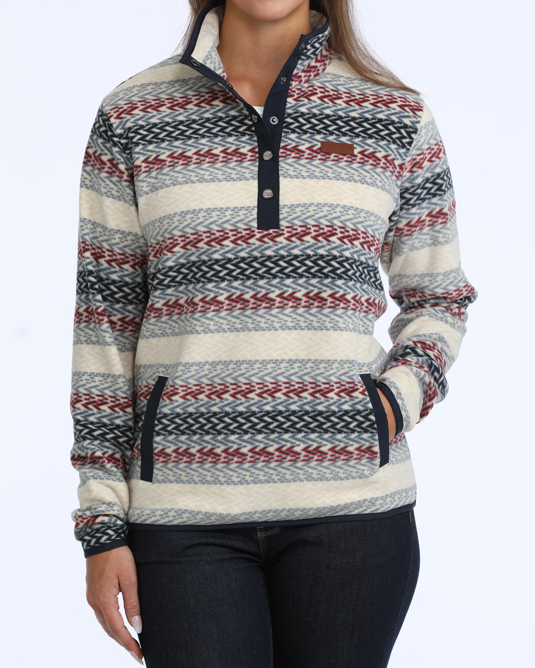 woman wearing a multi colored fleece Cinch sweater and blue jeans on a white background