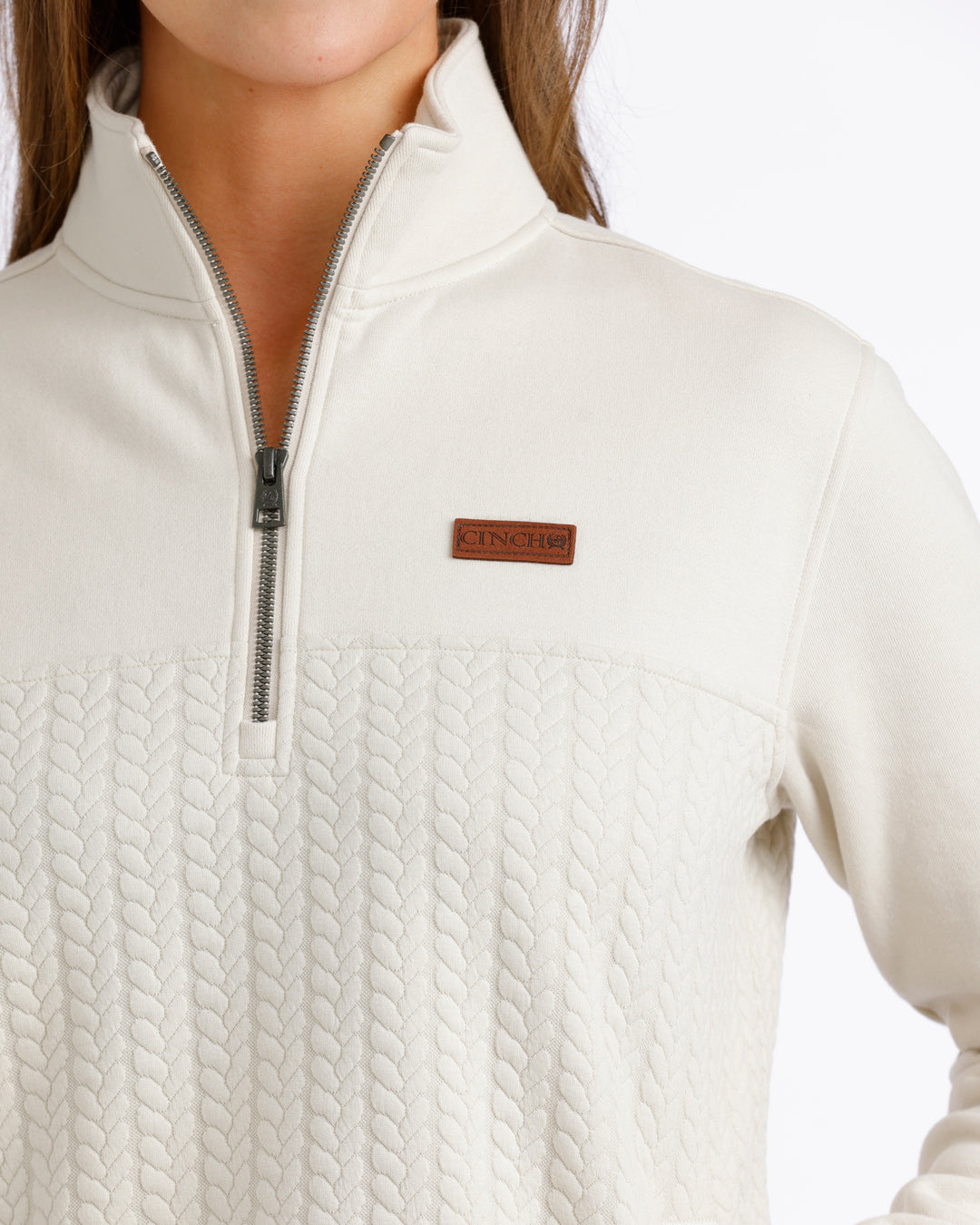 woman wearing a cream Cinch pullover sweater on a white background