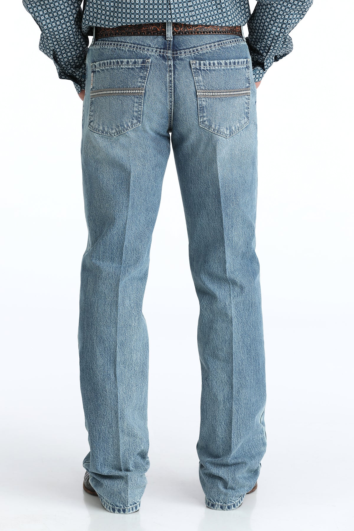 Relaxed light blue Cinch jeans worn by a person on a white background
