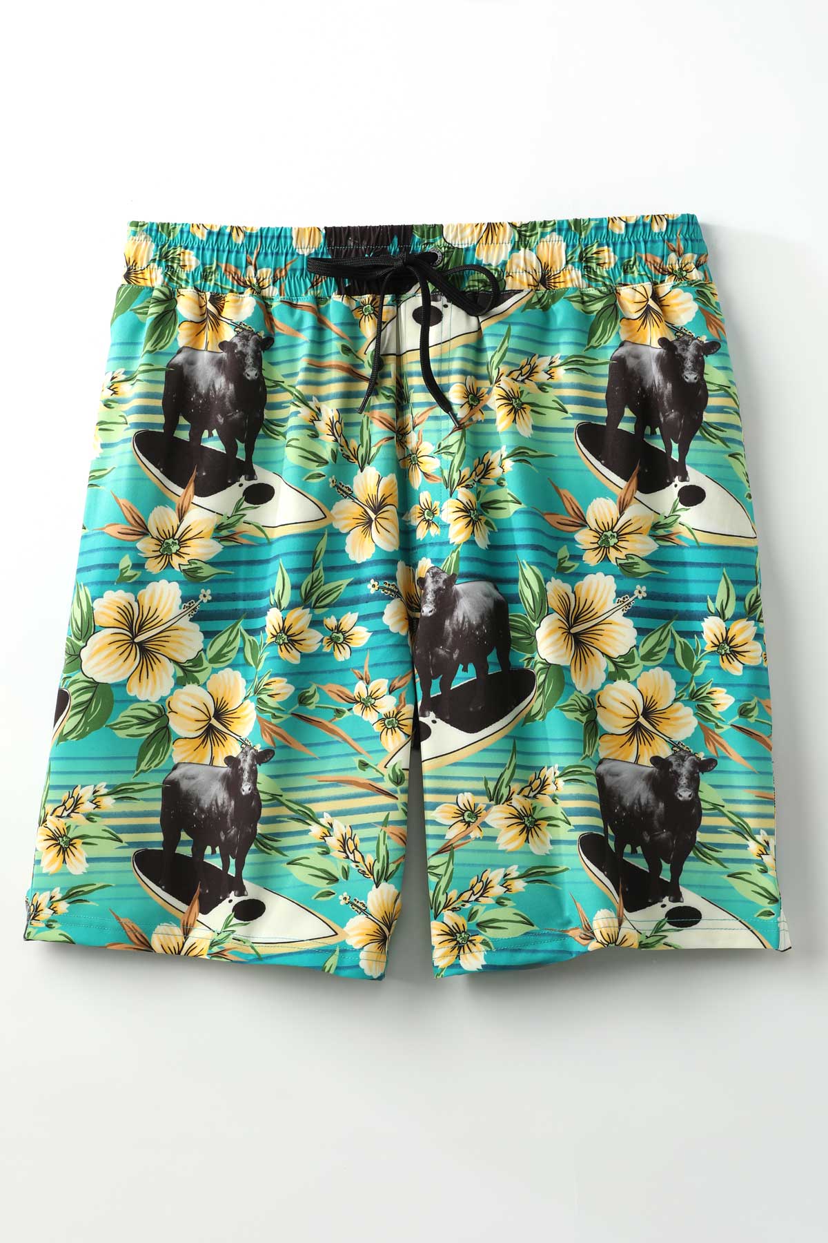 Hawaiian-style swim shorts by Cinch with black cow surfing design on a white background
