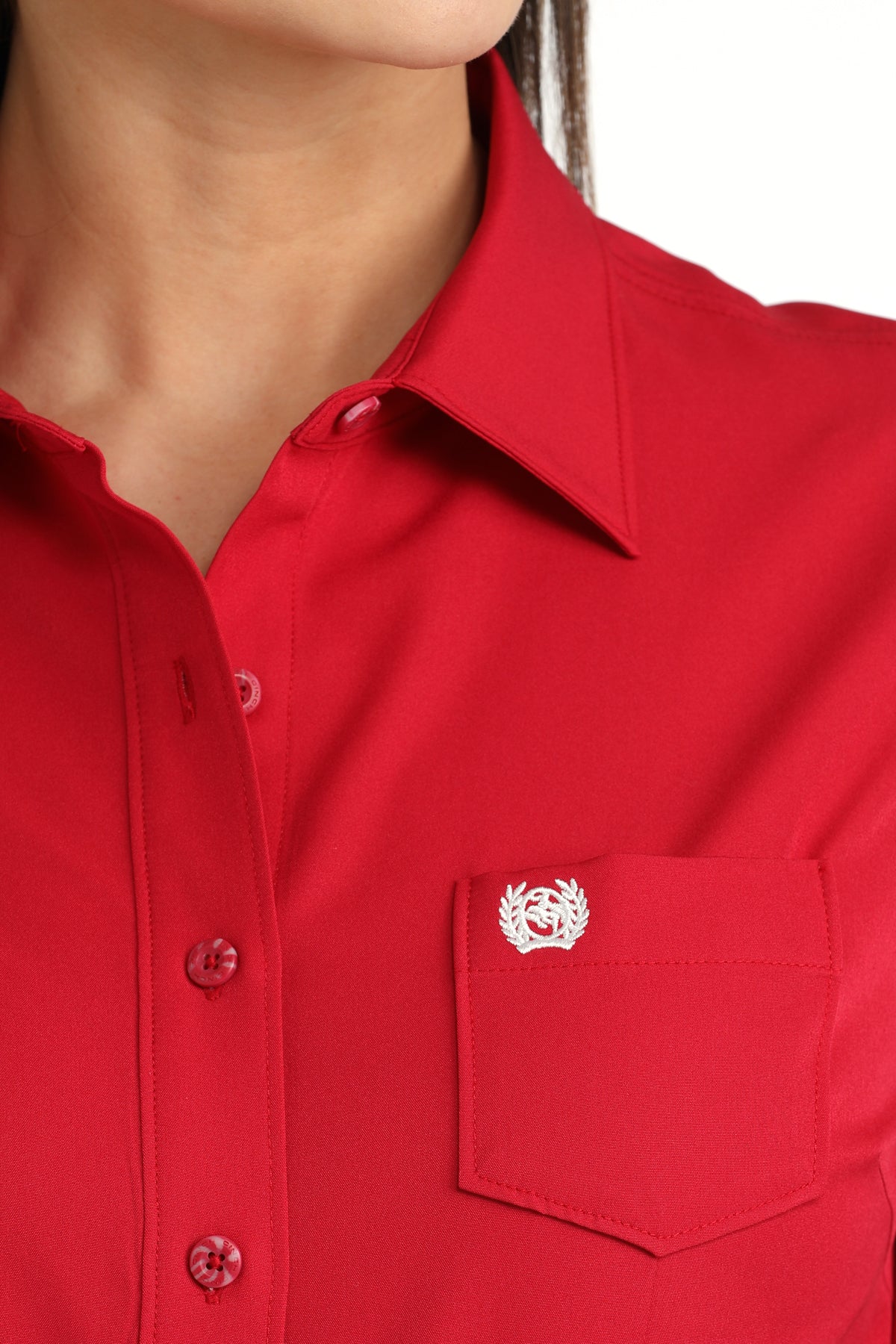 Close-up of a pink women's shirt with a cinch logo on the chest pocket.