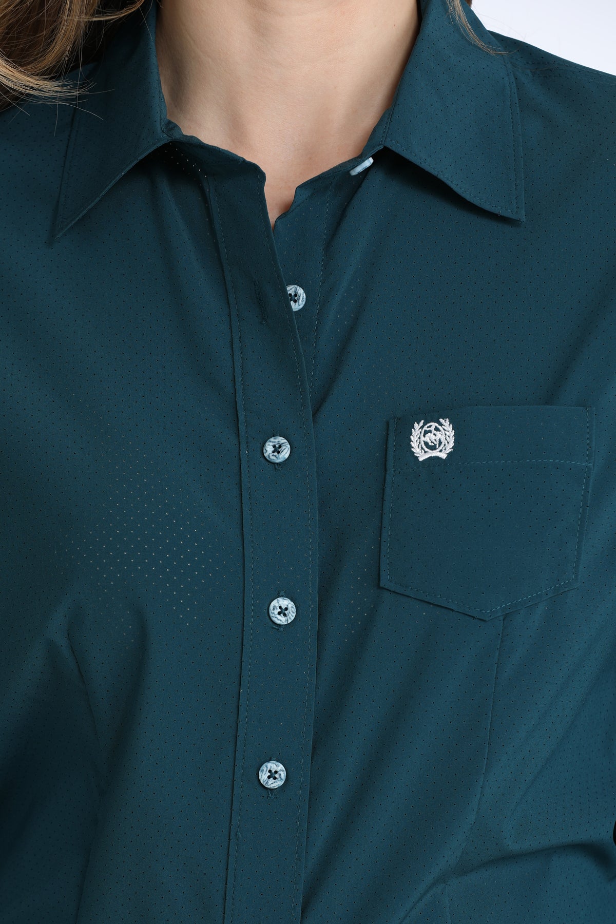 Close-up of a dark green Cinch shirt with a collar and button details.