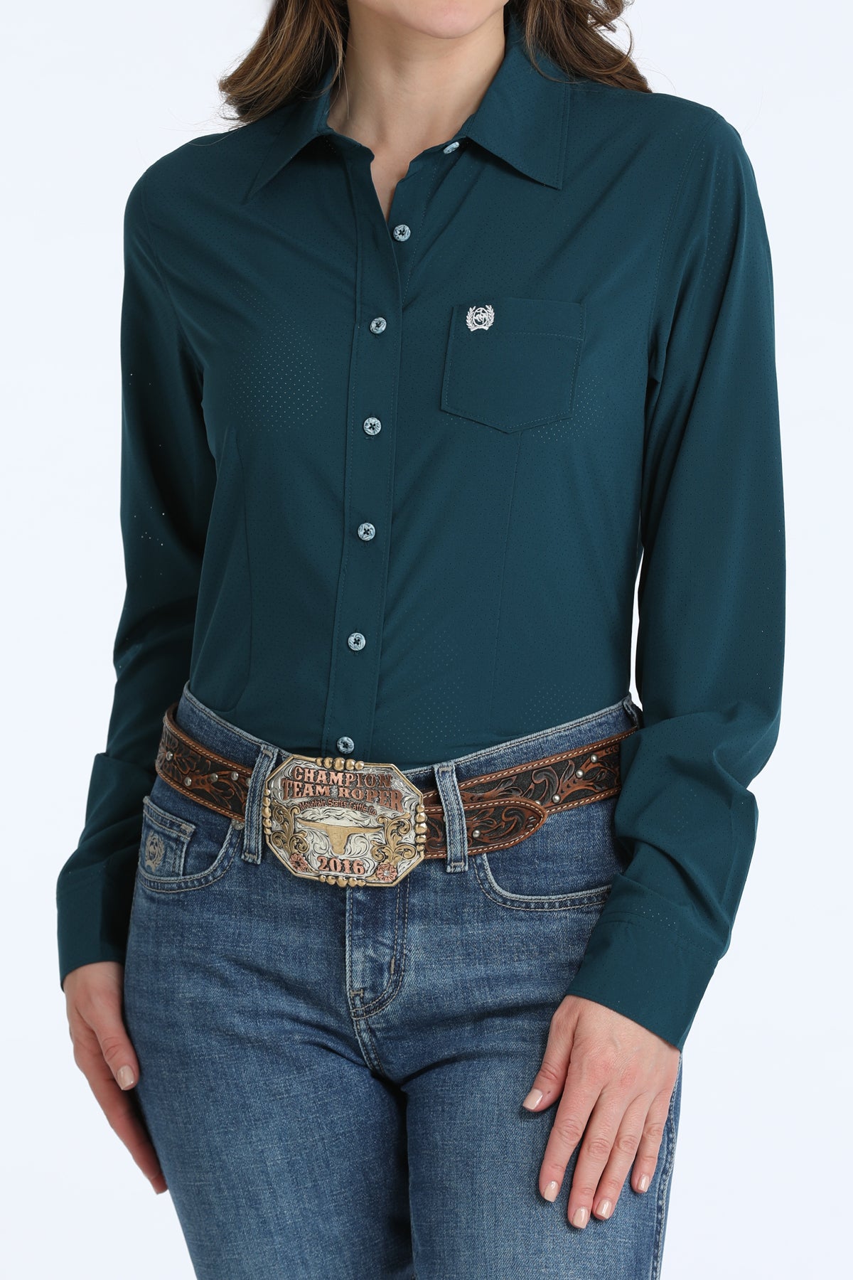 Person wearing a teal Cinch button-up shirt and jeans with a decorative belt on a white background