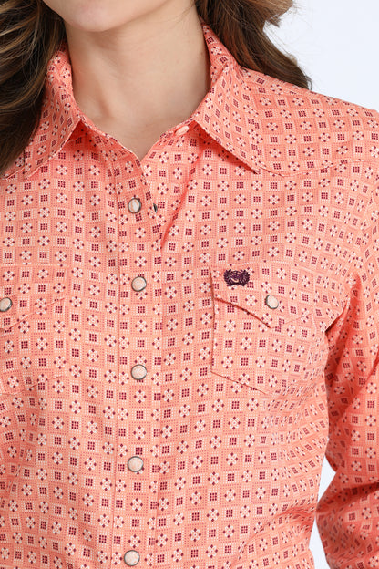 Close-up of a person wearing a pink patterned Cinch shirt with a blurred background