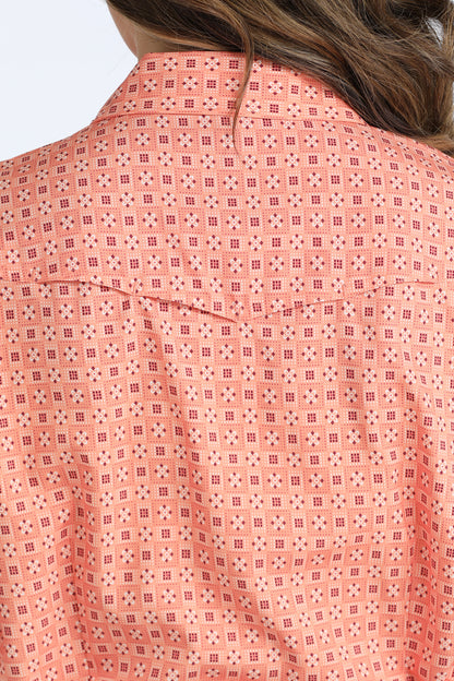 Close-up of a pink patterned Cinch shirt with a blurred background