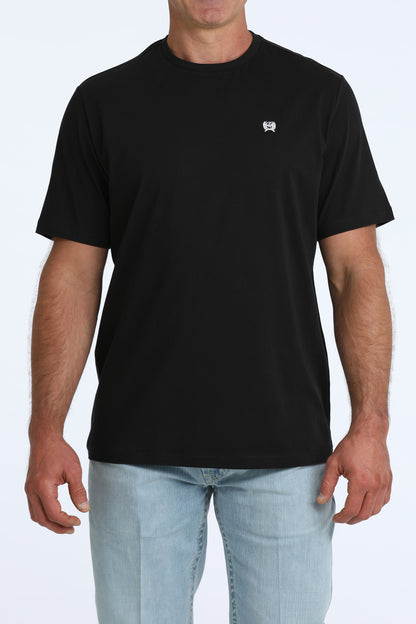 man wearing a black Cinch t shirt and blue jeans on a white background