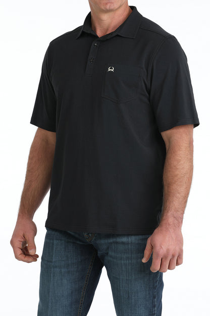 Man wearing a black polo shirt with a logo on a white background