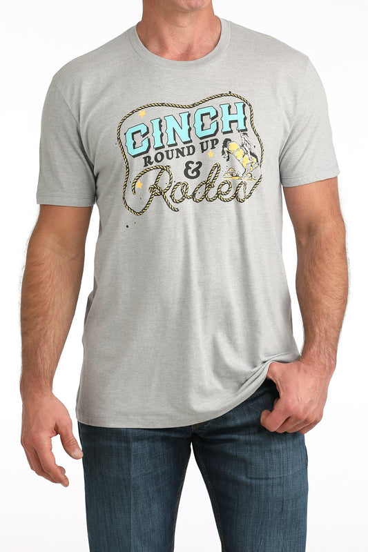 Man wearing a gray Cinch t-shirt with 'Cinch Round Up & Rodeo' graphic design.