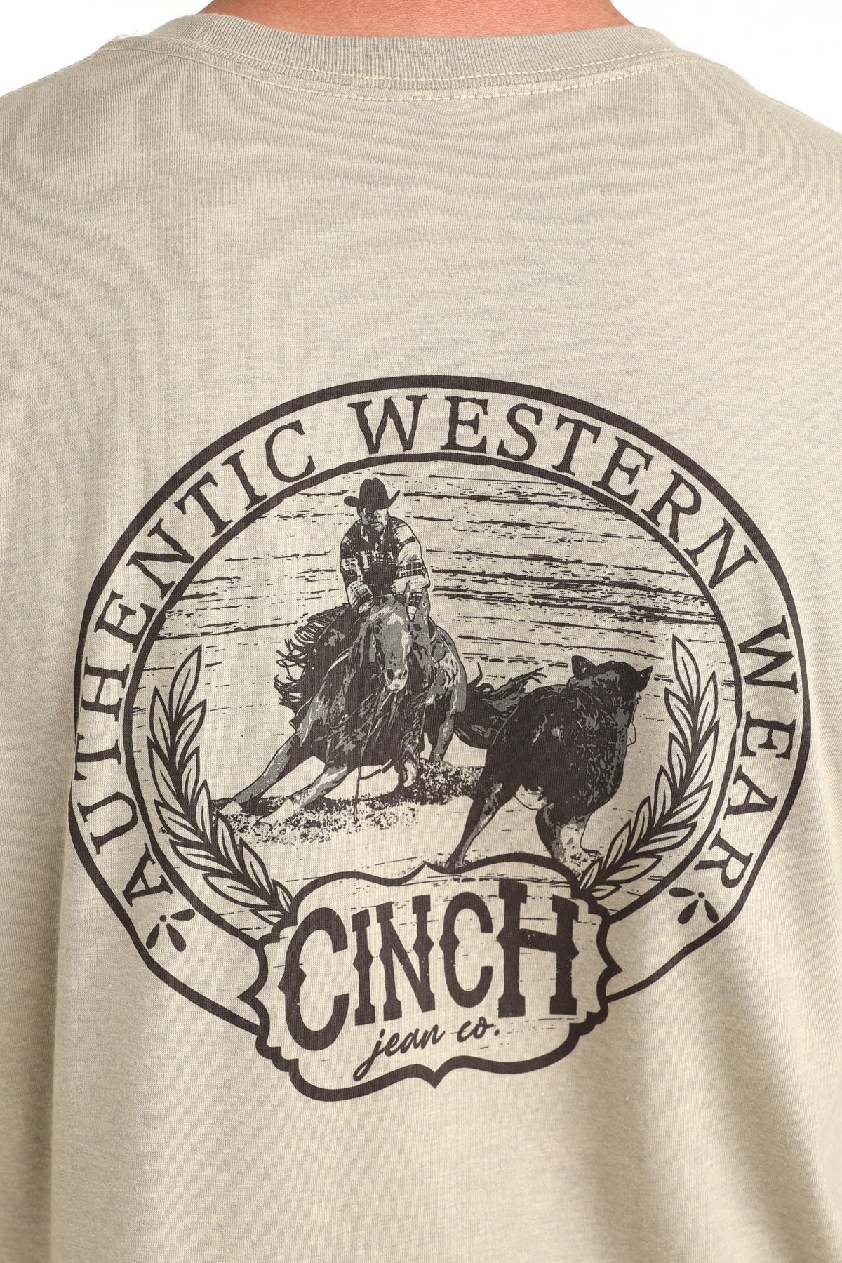 Beige t-shirt with 'Cinch Jean Co.' logo featuring a cowboy and cow on the back.