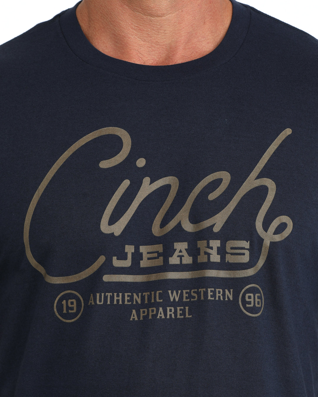 man wearing a navy Cinch shirt with the logo on it on a grey background