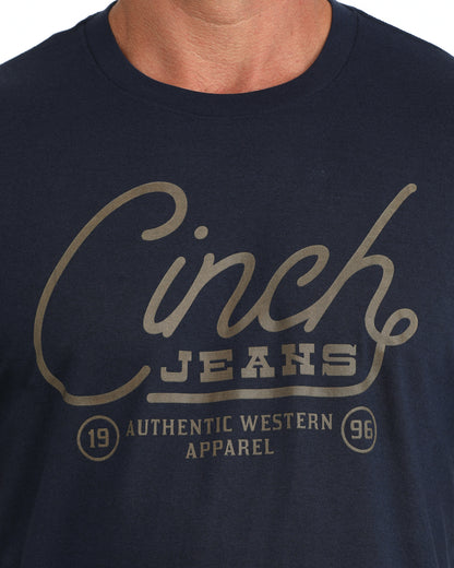 man wearing a navy Cinch shirt with the logo on it on a grey background