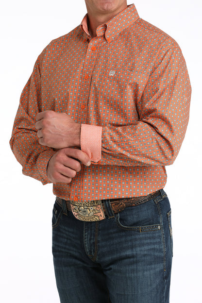 Man wearing an orange patterned 'Cinch' shirt and jeans on a white background