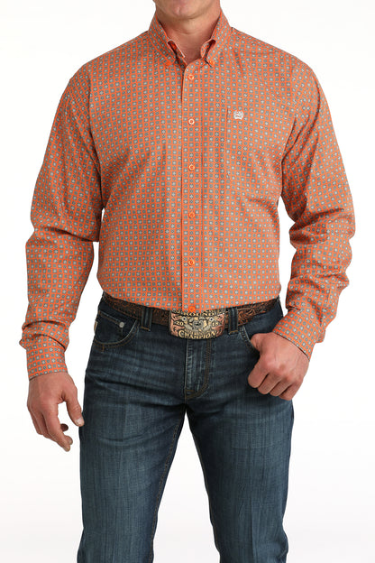 Man wearing an orange patterned 'Cinch' shirt and blue jeans on a white background