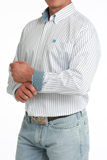 Man wearing a white striped Cinch shirt and light blue jeans with a belt.