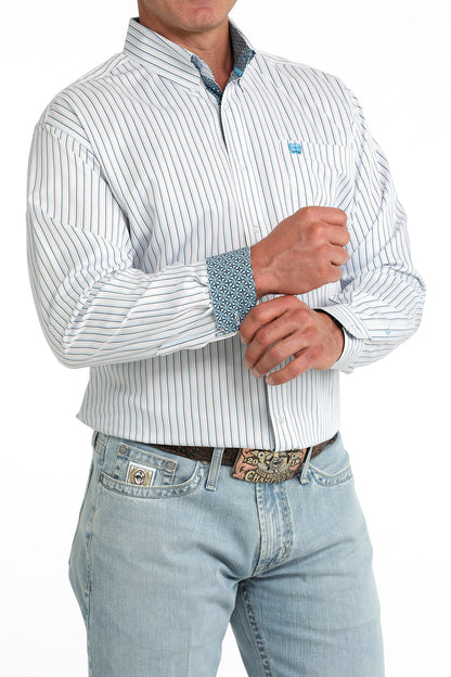 Man wearing a white striped Cinch shirt and light blue jeans with a belt.
