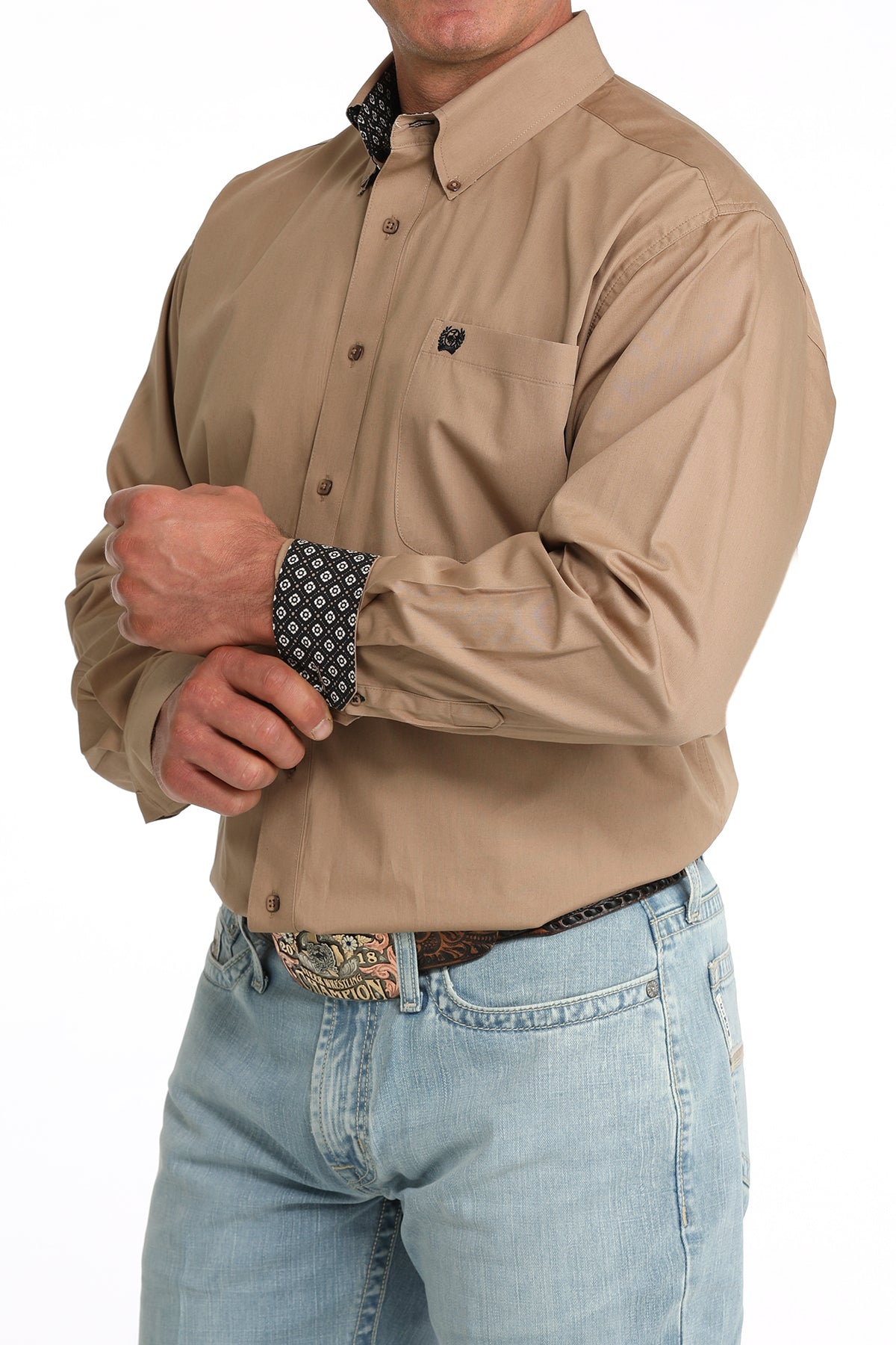 man wearing a brown Cinch shirt and blue jeans on a white background