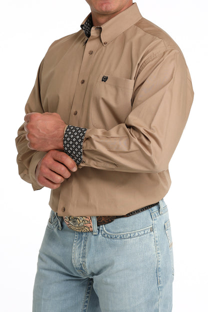 man wearing a brown Cinch shirt and blue jeans on a white background