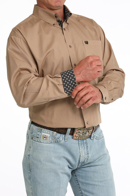 man wearing a brown Cinch shirt and blue jeans on a white background