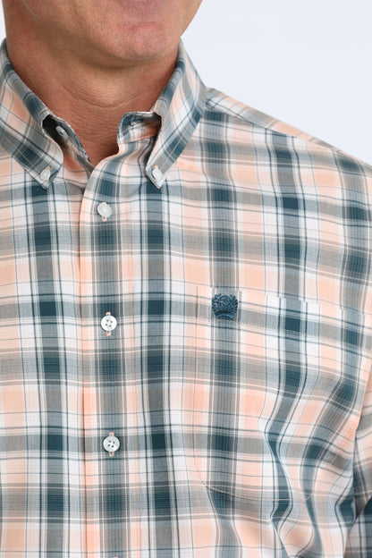 Close-up of a person wearing a plaid Cinch shirt with a neutral background