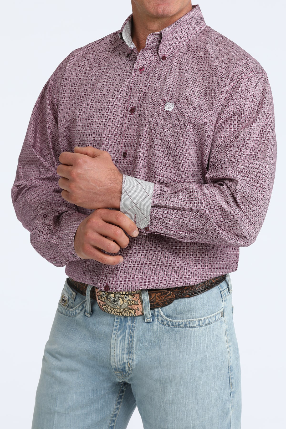 Man wearing a purple checkered Cinch shirt and light blue jeans on a white background