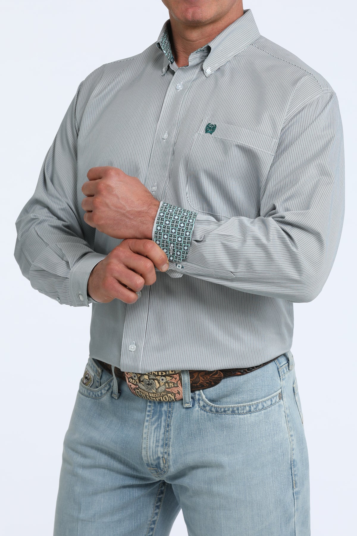 Man wearing a light gray Cinch patterned shirt and light blue jeans on a white background