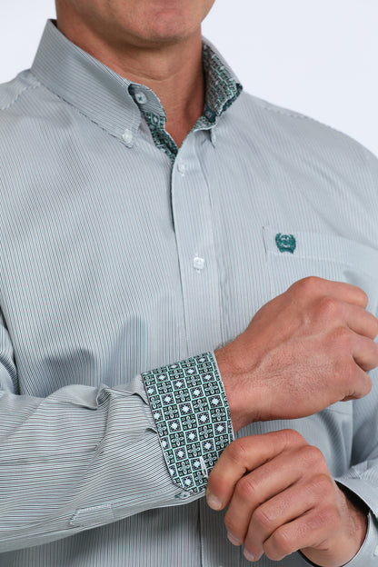 Close-up of a person wearing a light green Cinch dress shirt with patterned cuffs and collar.