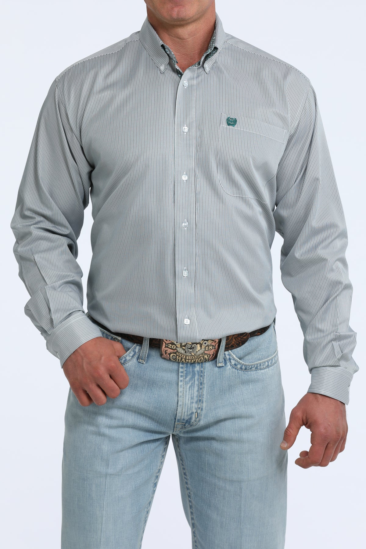 Man wearing a light gray Cinch patterned shirt and light blue jeans on a white background