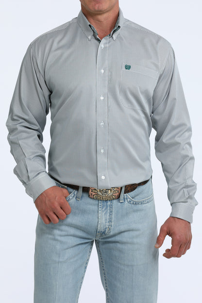 Man wearing a light gray Cinch patterned shirt and light blue jeans on a white background