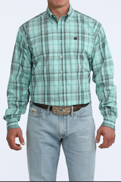 Man wearing a green plaid Cinch shirt and light blue jeans on a white background