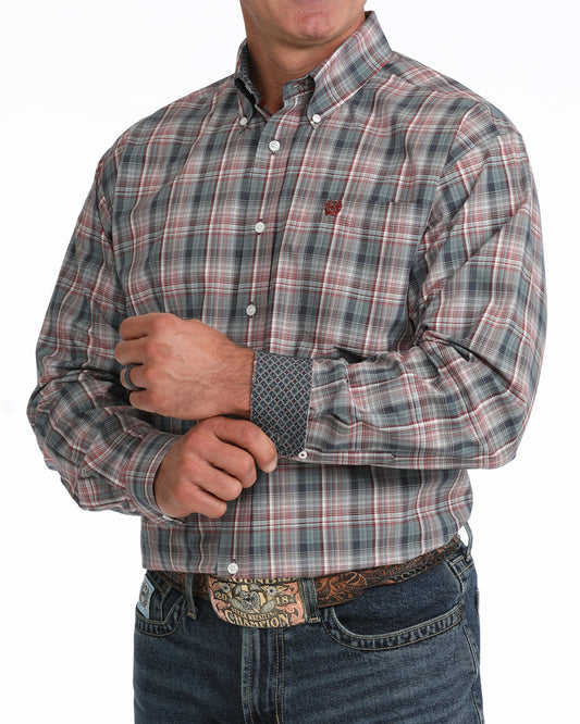 A man wearing a long-sleeve button-down plaid Cinch shirt in muted gray, red, and green tones, paired with dark blue jeans and a western belt buckle, shown against a plain white background.