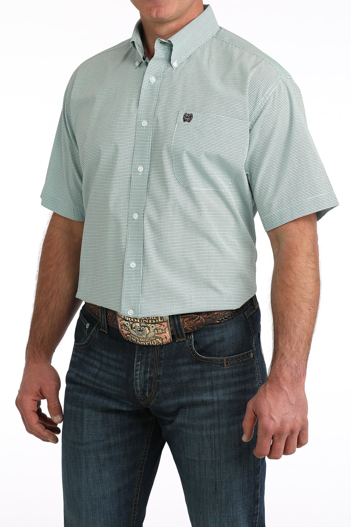 Man wearing a light blue short-sleeve button-up 'Cinch' shirt and dark jeans on a white background