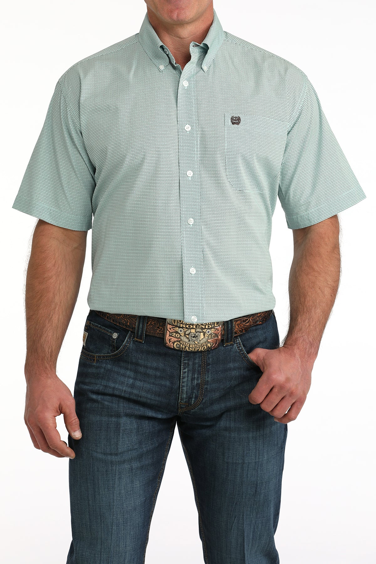 Man wearing a light blue short-sleeve button-up 'Cinch' shirt and dark jeans on a white background