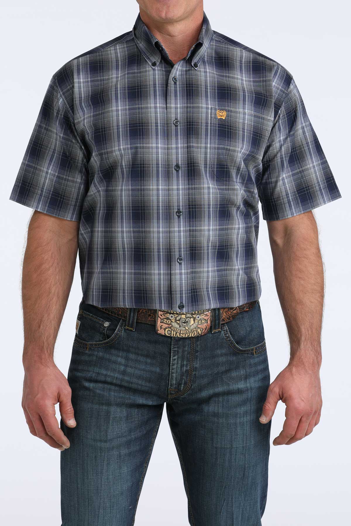 Man wearing a plaid cinch short sleeve shirt and jeans on a white background