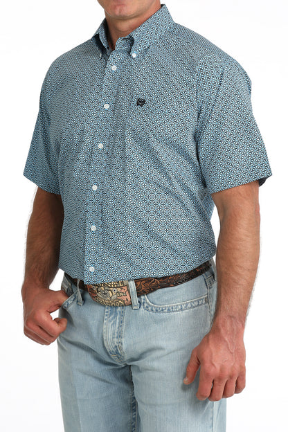 man wearing a blue patterned Cinch shirt with blue jeans on a white background
